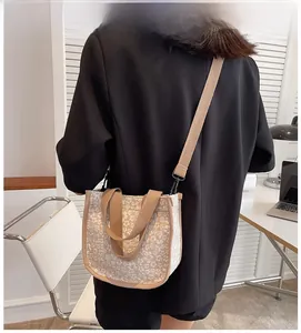 Beige floral canvas crossbody bag shown on model in a minimalist modern interior