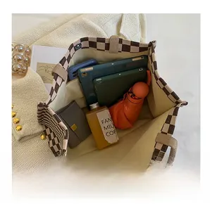 Detailed inner view of checkerboard tote bag showing spacious storage and side pocket