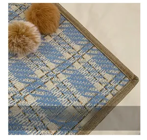 Detailed close-up of woven tote bag fabric with blue jacquard and gold thread finish