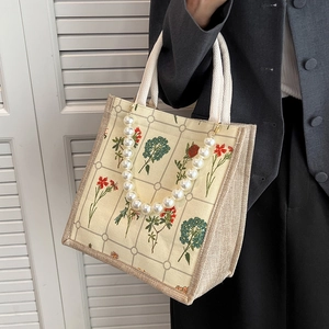 Vintage floral tote bag with large pearl chain and cotton rope handles on a grey suit model