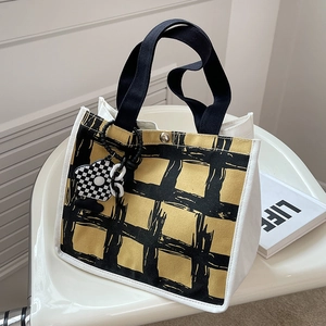 Minimalist canvas tote bag with yellow and black plaid pattern and floral charm