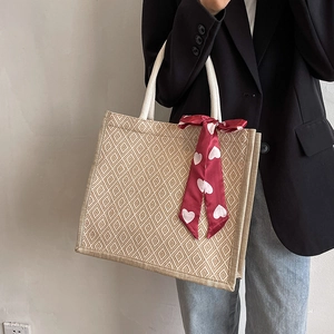 Beige linen tote bag with geometric texture, rope handles and red heart silk scarf