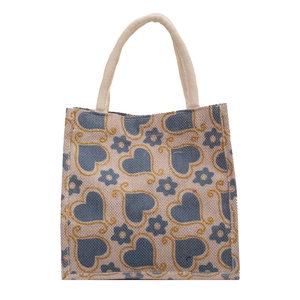 Minimalist jute tote bag with blue heart floral print and woven handles on white backdrop