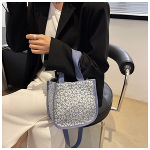 Mini light blue floral canvas crossbody bag shown with a stylish casual outfit