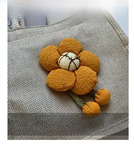 Detail of handmade fabric flower decoration with orange petals on a linen lunch bag