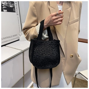 Detail of black floral jacquard canvas bag styled with a beige blazer for a Korean look