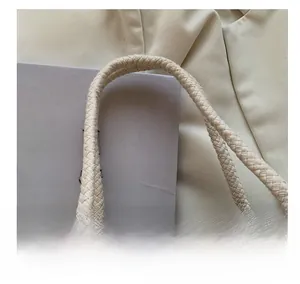 Close-up of the thick woven handles and natural linen texture of this beige lunch tote