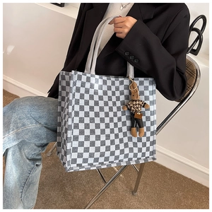 Close-up of checkerboard canvas tote bag featuring a cute bunny doll accessory