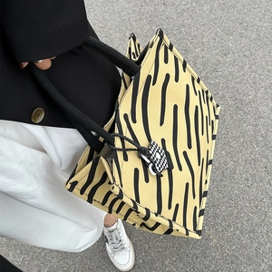 Grande borsa tote in tela gialla a righe nere con manici in corda e ciondolo a scacchi
