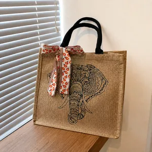 Détail du cabas en jute avec imprimé mandala éléphant et foulard floral sur l'anse
