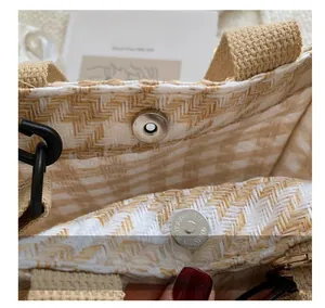 Vue détaillée du fermoir magnétique argenté et du tissage du sac en toile beige