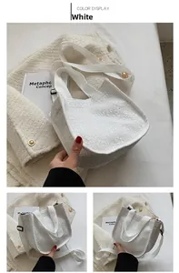 White jacquard canvas tote bag with dual handles and shoulder strap in aesthetic setting