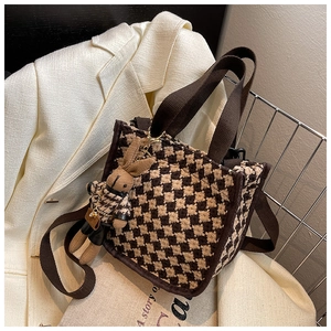 Detail of brown houndstooth tote bag with matching fabric strap and cute rabbit pendant