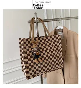 Detail view of checkerboard tote bag in coffee brown with cute bunny doll charm