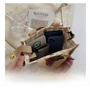 Détail de mini sac cabas tissé montrant la capacité pour téléphones et portefeuille