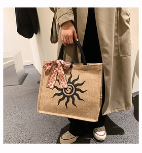 Détail du grand sac cabas en jute avec imprimé soleil et foulard floral décoratif
