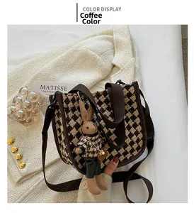Detail of coffee houndstooth canvas tote bag with brown strap and rabbit doll charm
