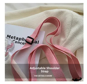 Détail de la bandoulière réglable tissée rose avec curseur noir pour sac à main moderne