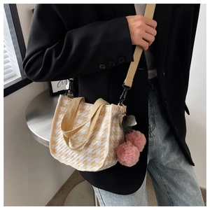 Détail du sac cabas à motif pied-de-poule crème avec breloque cerise en peluche rose