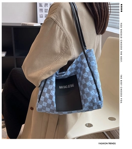 Detail of blue and gray checkered quilted tote bag with soft puffer texture