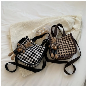 Detail view of checkerboard canvas tote bags with cute bunny charms and wide straps