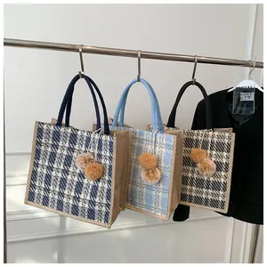 Hanging display of large tote bags in three checkered colors with plush ball charms