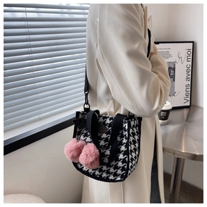Détail d'un sac en toile pied-de-poule avec charm cerise rose et bandoulière noire