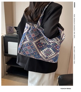 Detail of multi-color geometric woven tote bag with FASHION label and matching strap