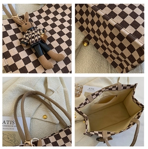 Detail view of checkerboard tote bag with woven handles and cute rabbit plush charm