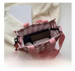 Vue intérieure du sac en toile à carreaux roses avec boucle magnétique et essentiels