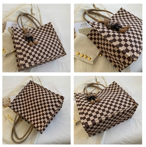 Detail view of checkerboard tote bag with hemp rope handles and a cute bear charm