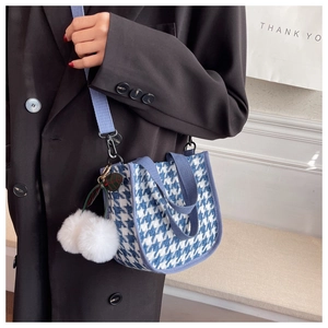 Détail du sac en toile à motif pied-de-poule bleu avec breloque boule de peluche
