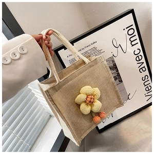 Close-up of linen lunch tote bag featuring a cute yellow fabric flower charm and rope handles