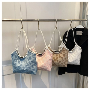 Detailed set of floral jacquard tote bags in blue pink brown and white hanging on a rack