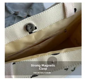 Detail view of canvas tote bag featuring a secure magnetic snap and zippered inner pocket