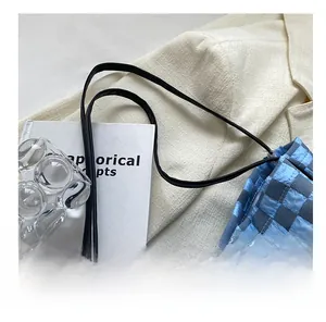 Close-up of the black synthetic leather handles and blue checkerboard tote bag details