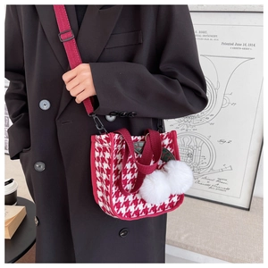 Détail du sac à main pied-de-poule rouge avec pompons blancs et bandoulière réglable