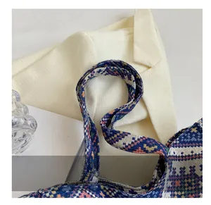 Detail of geometric pattern woven shoulder strap on a vibrant jacquard tote bag