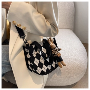 Detail der karierten Stricktasche mit süßem Hasenanhänger und breitem Schultergurt