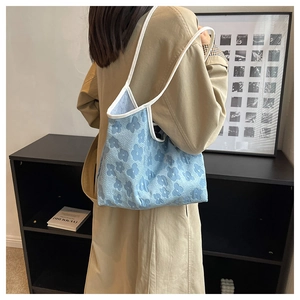 Close-up of light blue floral jacquard tote bag with white contrast piping details