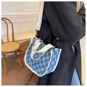 Détail du sac cabas en toile à damier bleu avec bandoulière tissée blanche