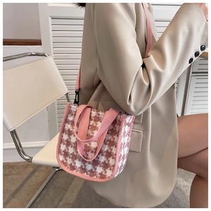 Détail du petit sac en toile à motif pied-de-poule rose avec bandoulière réglable