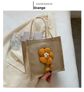 Detail of cute linen lunch bag featuring a 3D orange flower and white woven handles