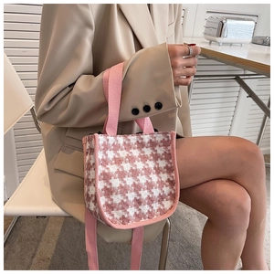 Détail d'un sac bandoulière en tweed pied-de-poule rose et blanc avec poignée pour femme