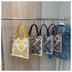 Close-up of four ethnic jacquard tote bags with geometric patterns on a hanger