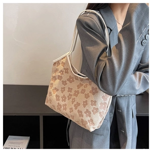 Detail of vintage floral pattern on cream canvas tote bag worn with grey blazer