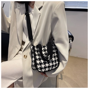 Détail du petit sac bandoulière en tweed pied-de-poule avec sangle large et bord noir