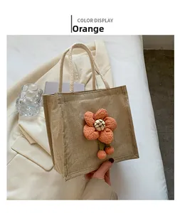 Detail of cute linen lunch bag featuring a 3D orange red flower and woven rope handle