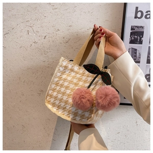 Détail du sac à main en toile pied-de-poule avec breloques cerises et anse tissée