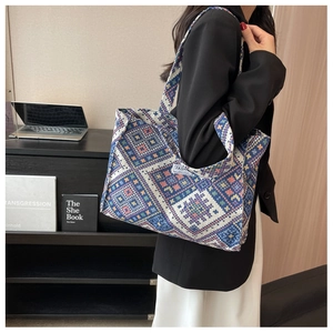 Close-up of geometric ethnic woven tote bag with a fashion instinct label and wide strap